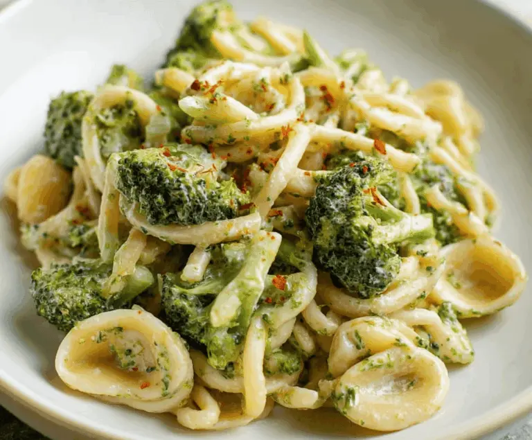 Creamy broccoli pasta dish with al dente noodles and fresh steamed broccoli, garnished with grated cheese and herbs.