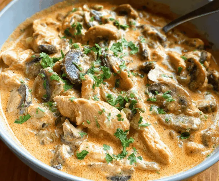 Creamy chicken stroganoff served over noodles with mushrooms and herbs in a savory sauce.