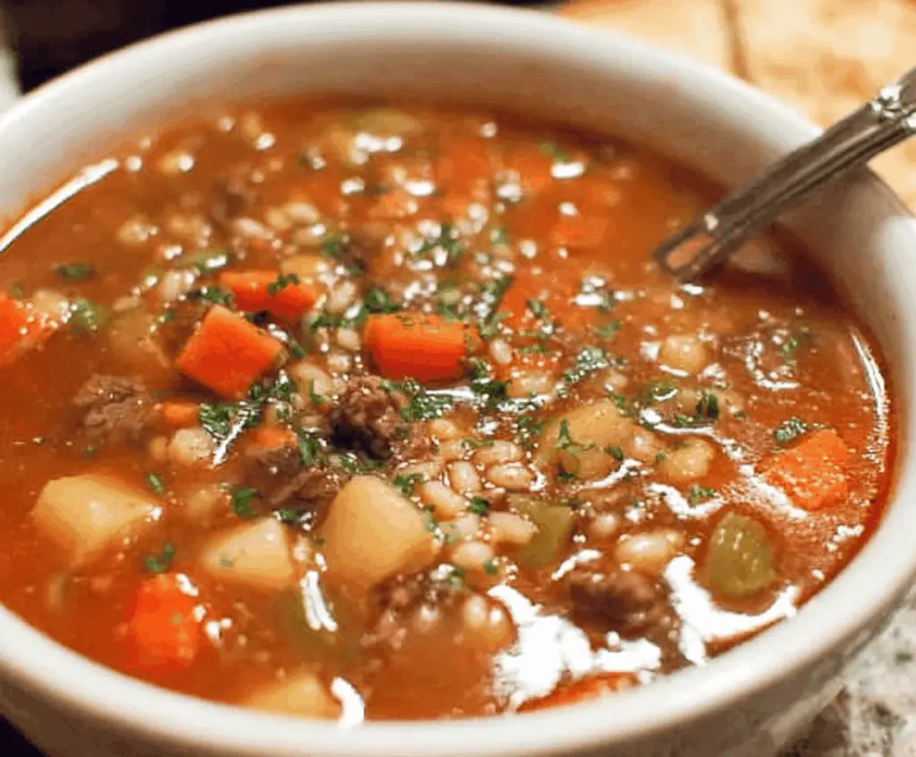 Hearty vegetable beef soup with tender beef chunks, fresh vegetables, and herbs in a bowl, perfect for a comforting meal.