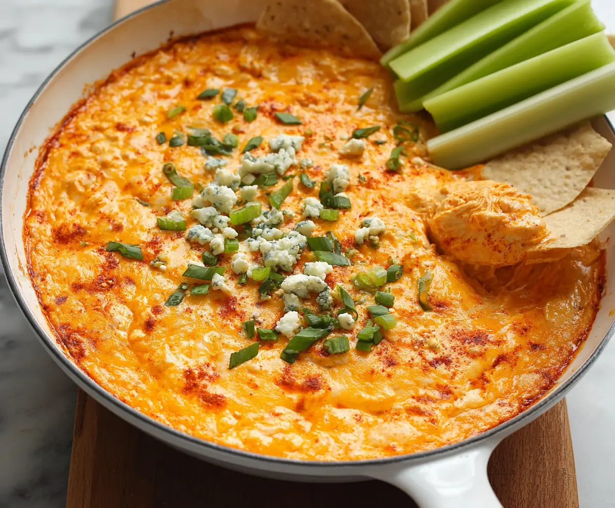 Creamy spicy buffalo chicken dip with melted cheese and crispy tortilla chips