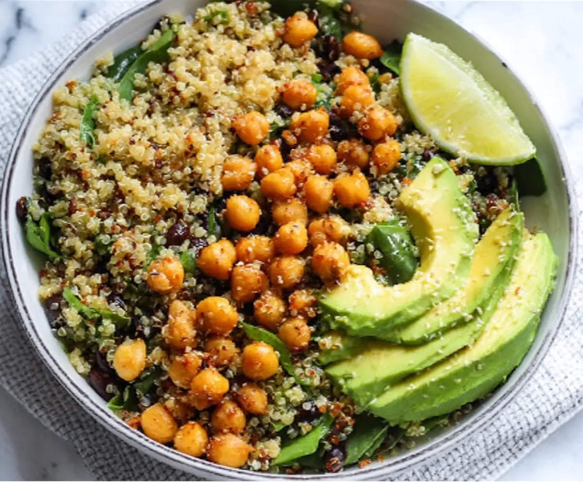 Healthy quinoa bowl topped with fresh avocado slices and savory chickpeas.