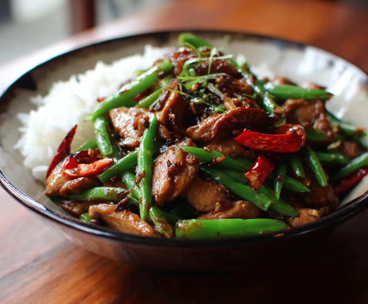 Delicious stir-fried Chinese garlic chicken served on a plate with fresh vegetables.