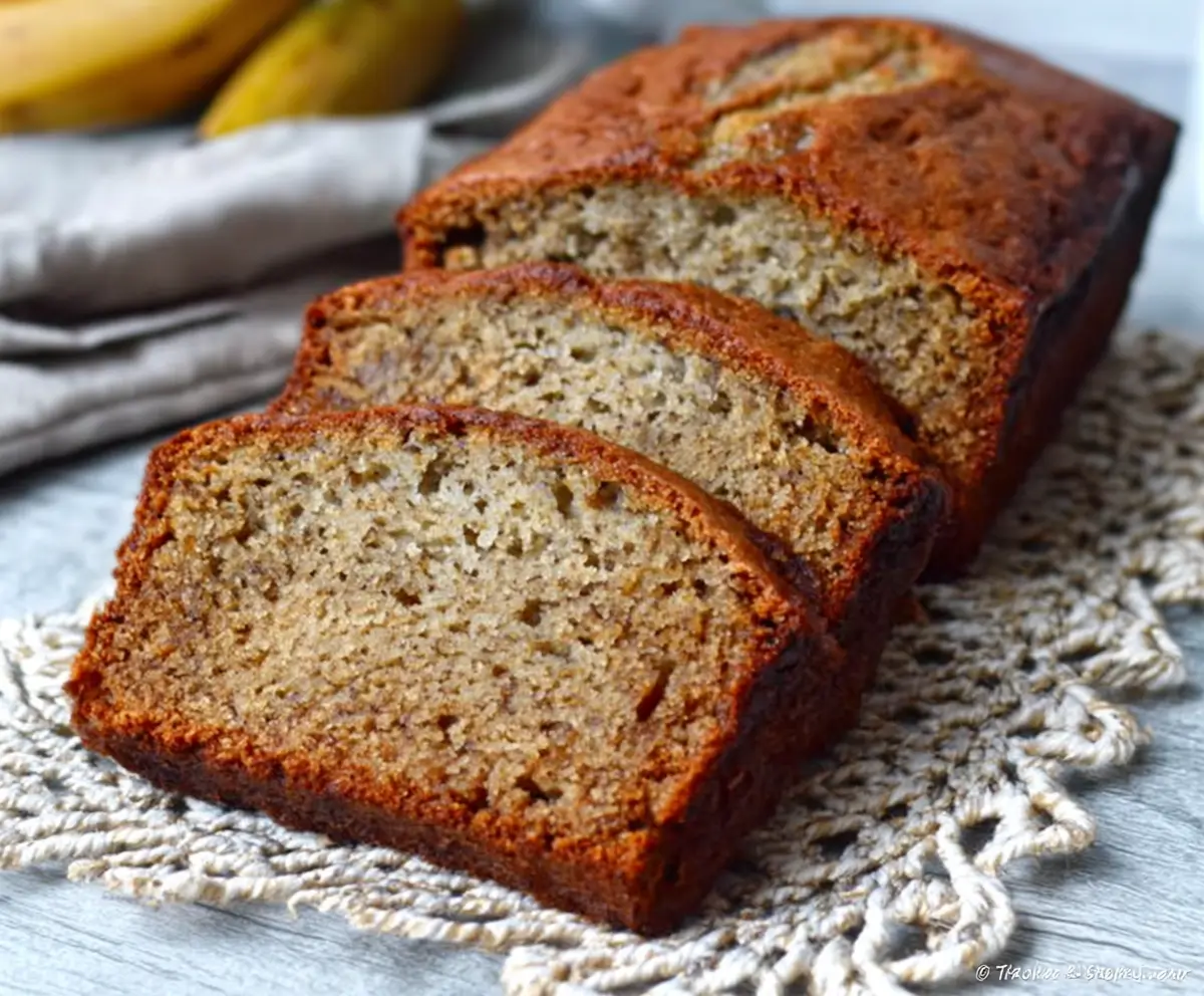 Delicious ultra-moist classic banana bread fresh out of the oven, showcasing a golden-brown crust and soft, banana-filled interior.