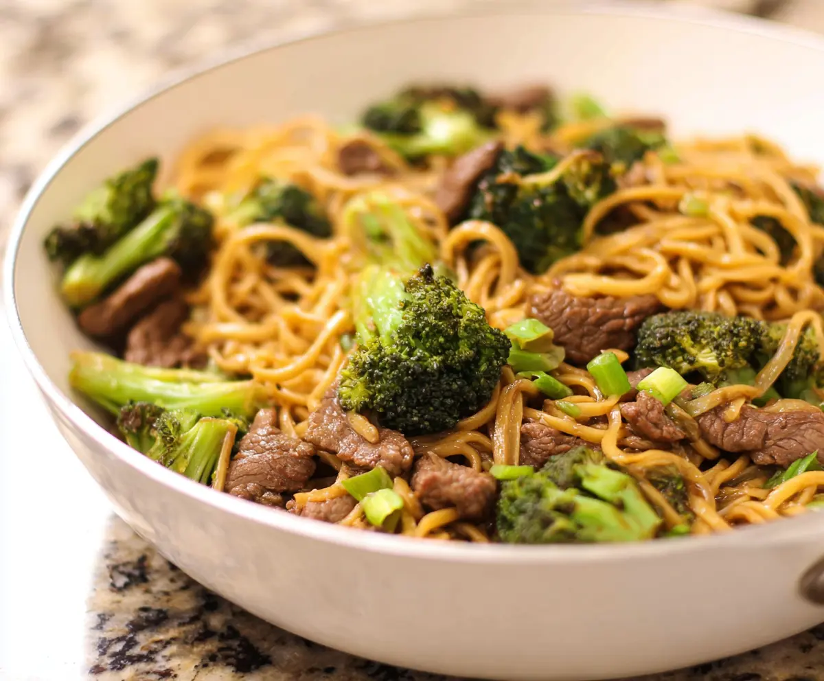 Delicious Garlic Ginger Beef and Broccoli Noodles served in a bowl with fresh herbs