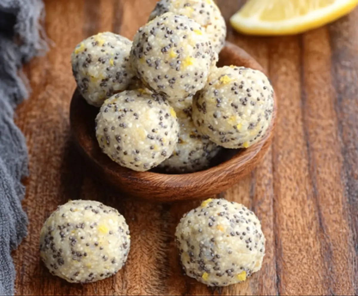 Healthy Lemon Poppy Seed Energy Bites with fresh lemons and poppy seeds in a glass bowl.